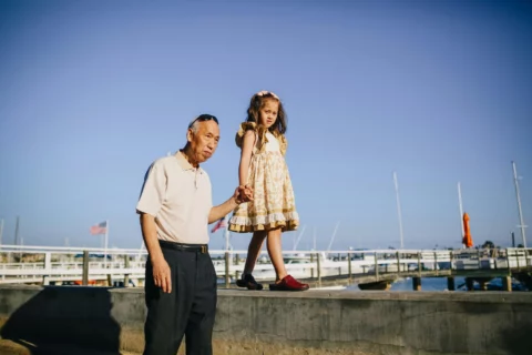 Grandpa walking holding hands with kinship child