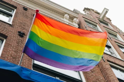Pride month rainbow pride parade flag on flagpole. Equal rights, LGBTQ+ pride month for gay, lesbian, bisexual, transgender equality.